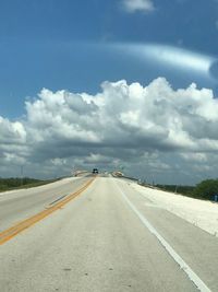Empty road against cloudy sky