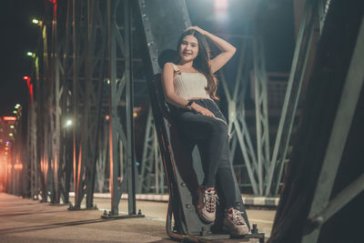 Portrait of smiling young woman standing at night