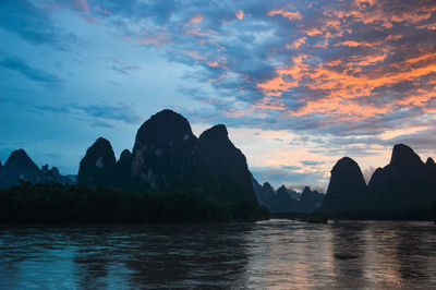 Scenic view of sea and mountains against sky