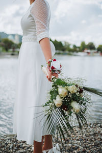 Midsection of bride holding bouquet