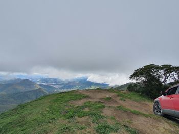 Car on road by mountains against sky