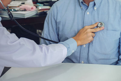 Midsection of doctor examining patient at hospital