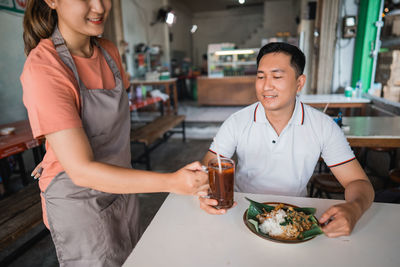 Portrait of young woman having food at restaurant