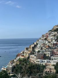 High angle view of townscape by sea against sky