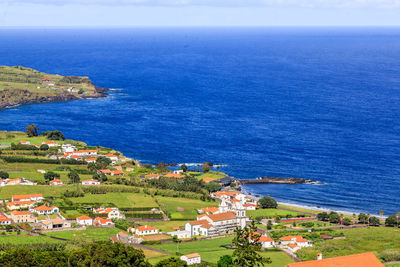 High angle view of townscape by sea against sky