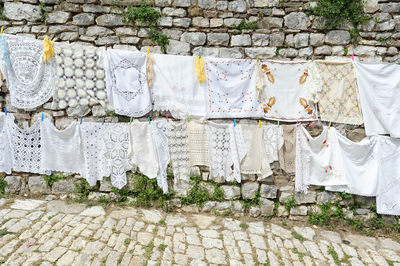 Clothes drying on footpath against wall