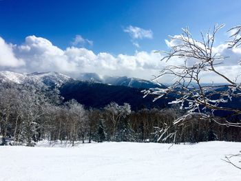 Snow covered land and mountains against sky