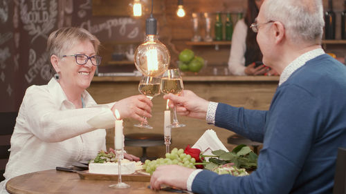 Portrait of smiling friends toasting wineglasses at restaurant