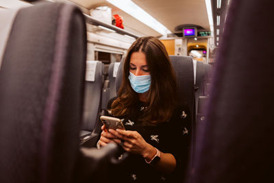 Woman using mobile phone in bus