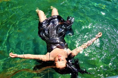 High angle view of young woman floating on swimming pool