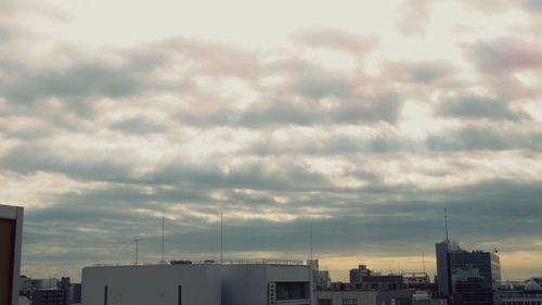 Buildings in city against cloudy sky