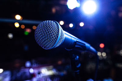 Microphone body on stage during a concert with colorful lights in the background