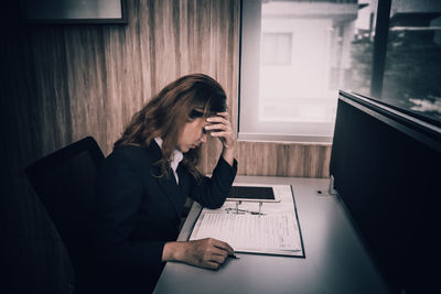 Young woman using mobile phone in laptop