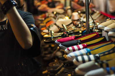 Midsection of woman shopping shoes in store