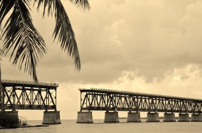 Pier on sea against cloudy sky