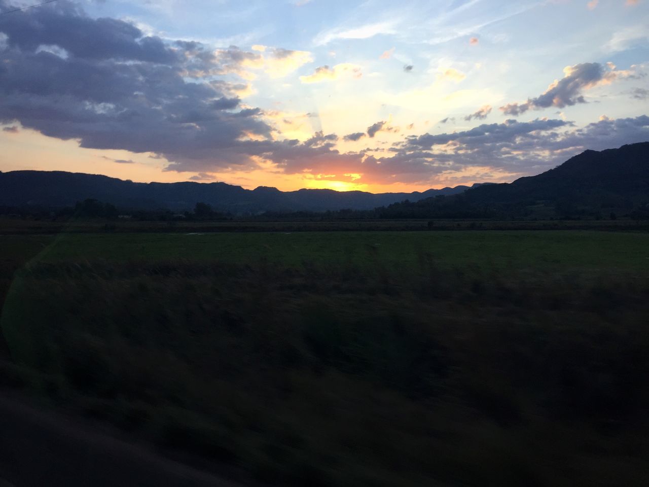 sunset, tranquil scene, scenics, tranquility, sky, beauty in nature, landscape, mountain, cloud - sky, nature, idyllic, silhouette, orange color, mountain range, field, cloud, sun, dramatic sky, cloudy, no people