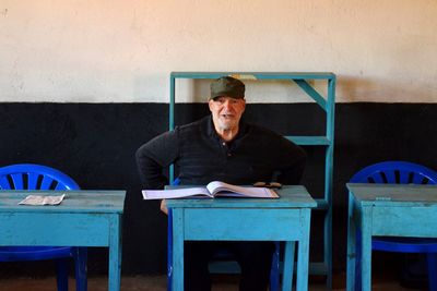 Full length of man sitting on table