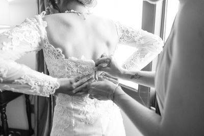 Midsection of bride holding wedding dress