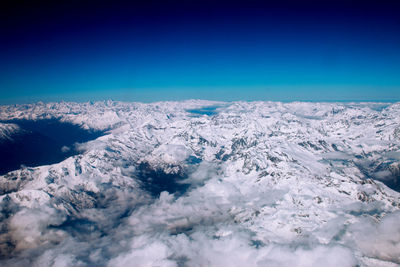 Scenic view of snowcapped mountains against clear blue sky