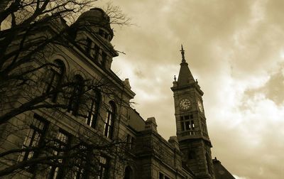 Low angle view of clock tower against cloudy sky