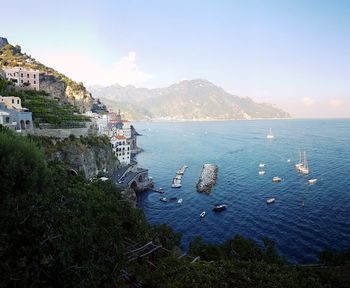 High angle view of townscape by sea against sky