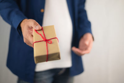 Midsection of man holding paper in box