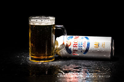 Close-up of beer glass on table against black background