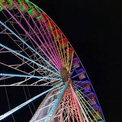 Low angle view of illuminated ferris wheel against sky at night