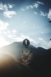 Person holding compass looking at mountain