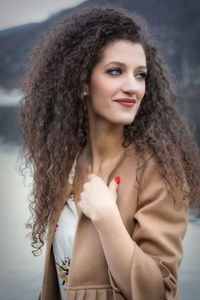 Curly hair woman looking away in city