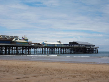 Pier on beach against sky