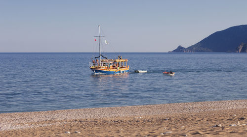 Boat sailing in sea against clear sky