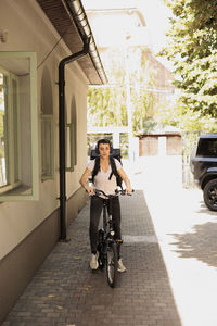 Side view of woman riding bicycle on street