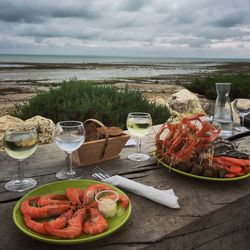 Close-up of food on table at beach against sky