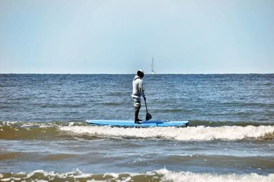 Man standing in sea against sky