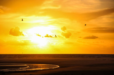 Scenic view of sea against orange sky