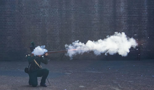 Army officer shooting through rifle against wall