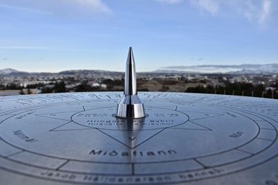 Close-up of clock on water against sky