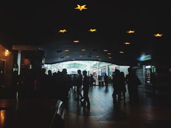 People walking in illuminated city at night