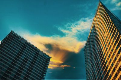 Low angle view of modern buildings against sky at sunset