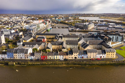 High angle view of river by buildings against sky