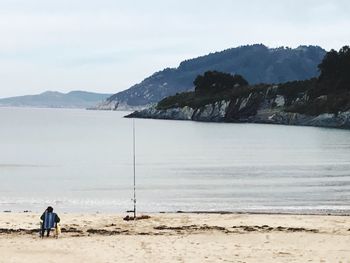 Man standing on beach against sky