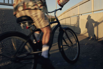 Low section of man riding bicycle on street