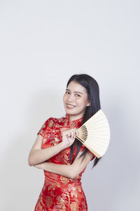 Portrait of a smiling young woman against white background