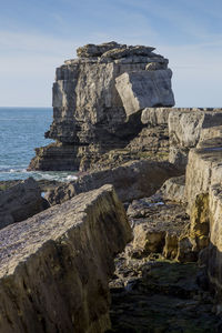 Scenic view of rocks on beach against sky