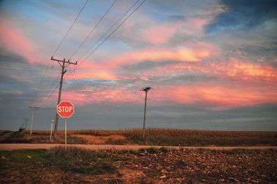 Stop sign on field during sunset