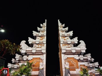 Low angle view of illuminated buildings against sky at night