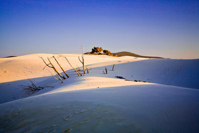 Scenic view of snowcapped mountains against clear blue sky