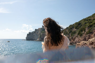 Rear view of woman in sea against sky