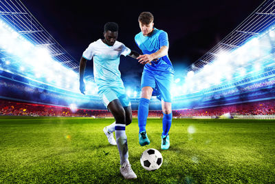 Full length of man playing soccer at night
